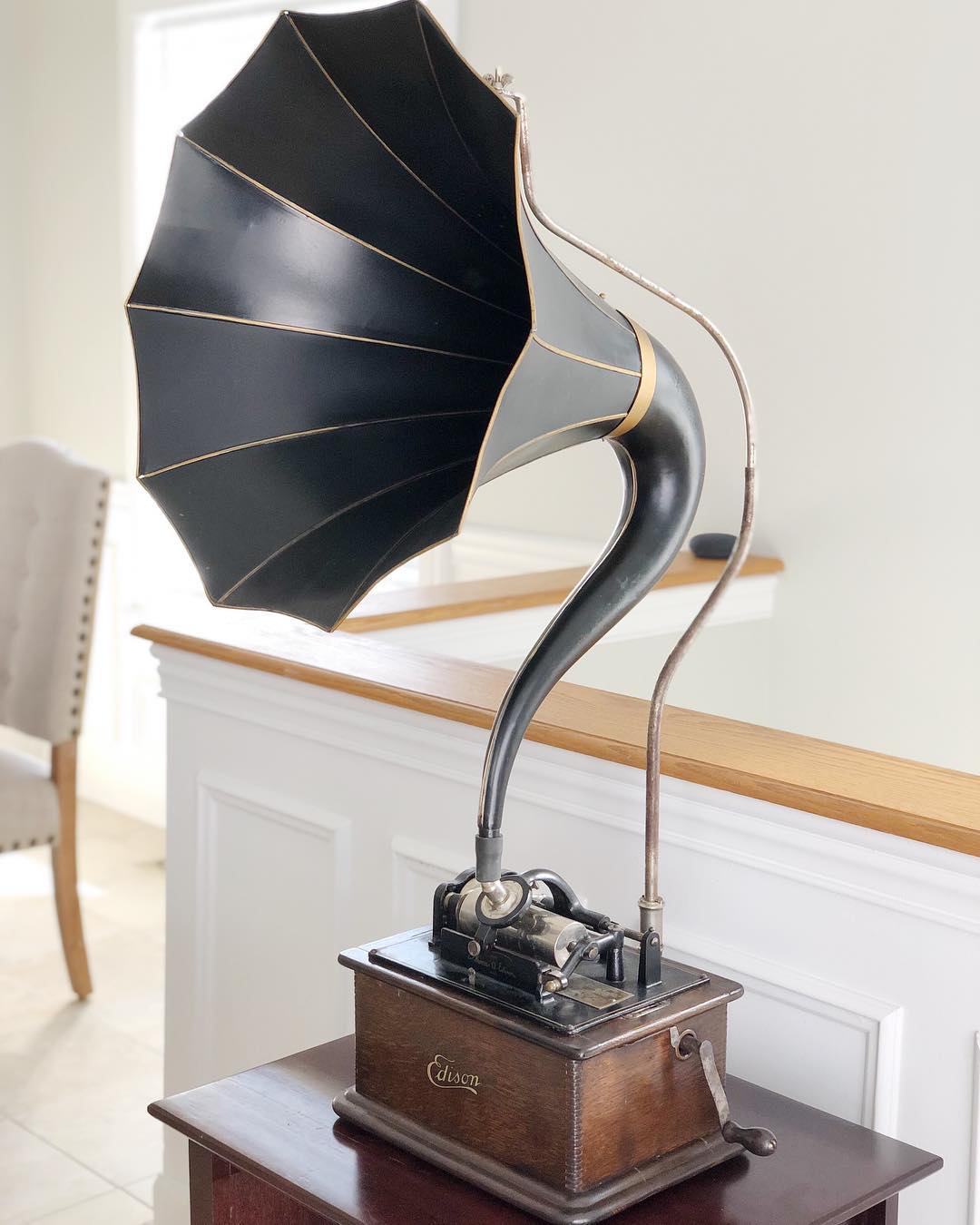 Edison cylinder phonograph with a large black and gold morning glory horn in a bright room